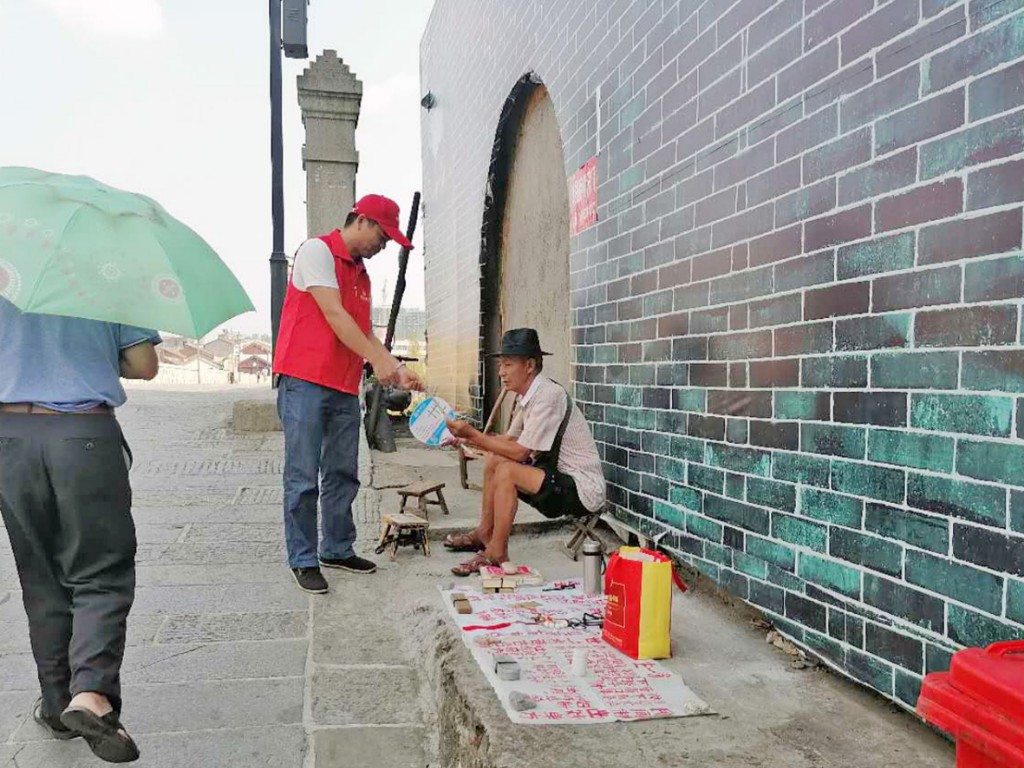 ▲民政志愿者在渌公桥向群众发放殡葬宣传资料