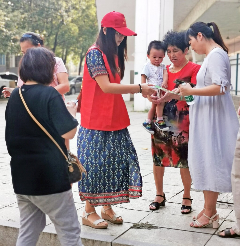 ▲民政志愿者在“一江两岸”风光带向市民发放丧葬宣传资料